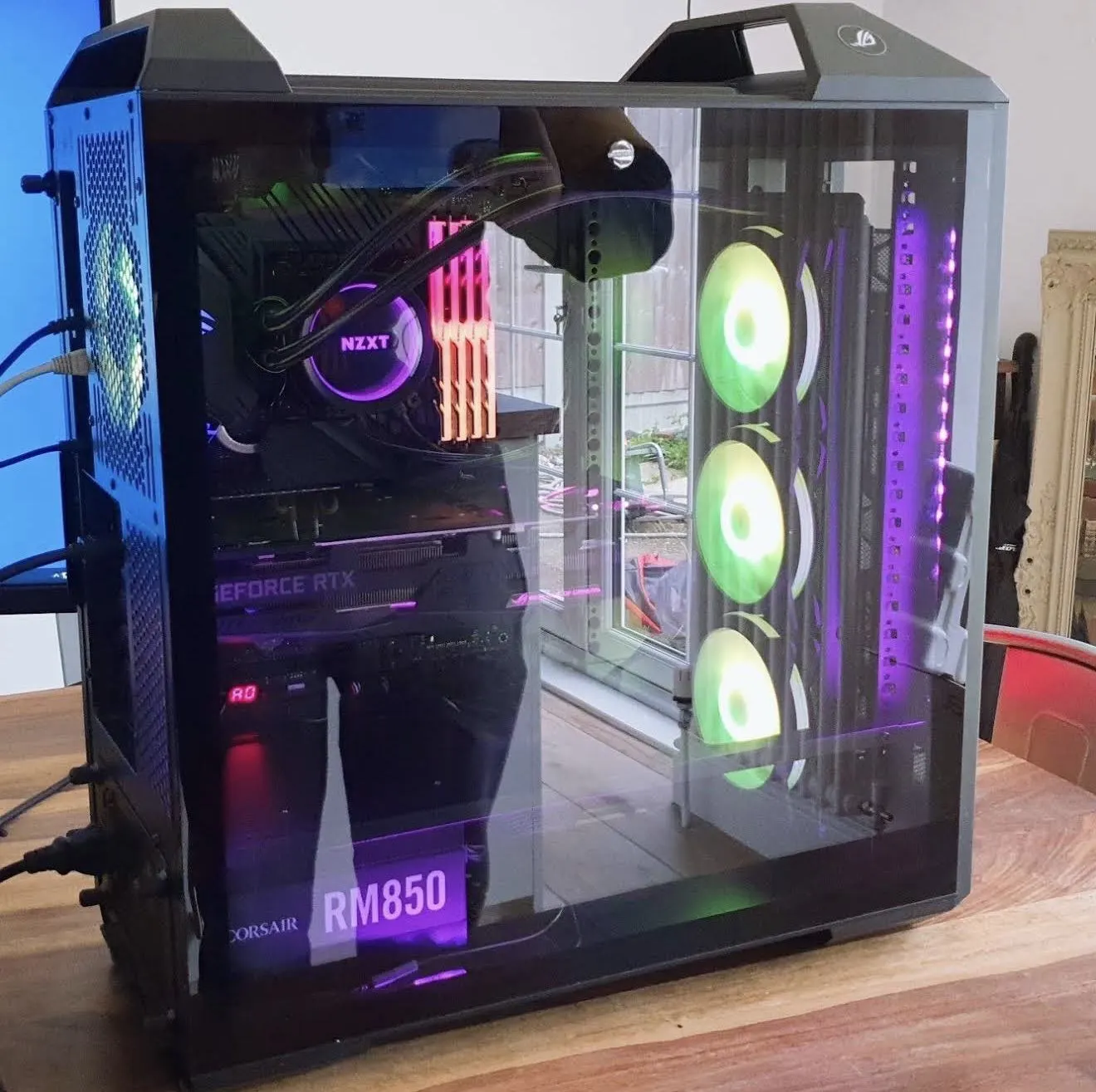A black tempered-glass PC with bright green fans and purple lighting.