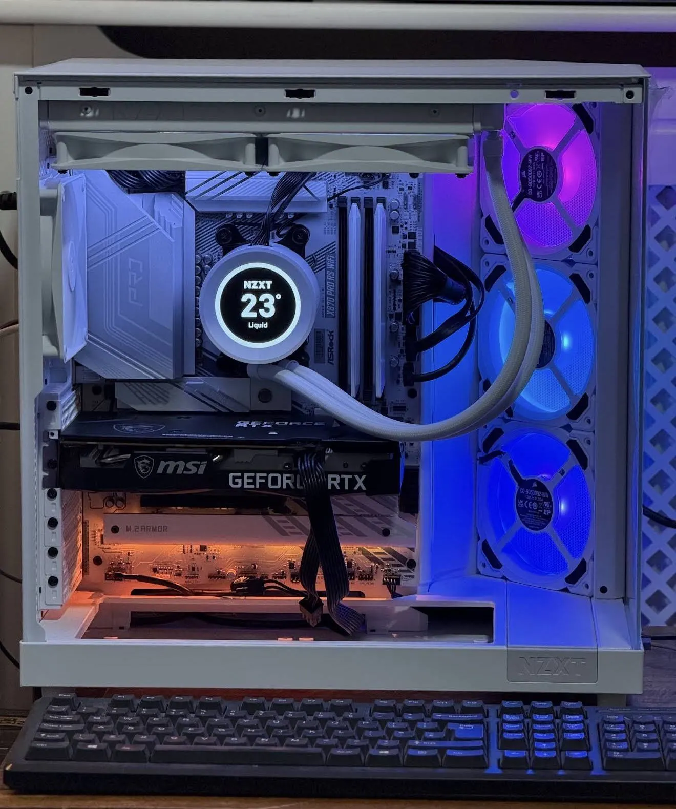A white PC build seen from the front with lit fans through the glass.